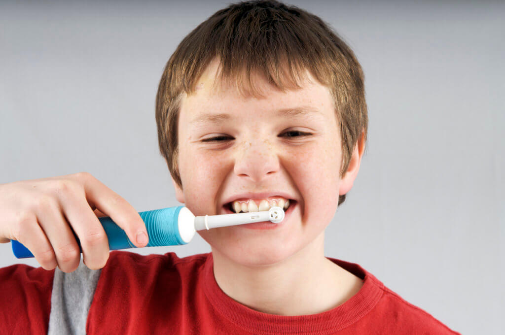 Electric toothbrushes, photo of boy brushing his teeth