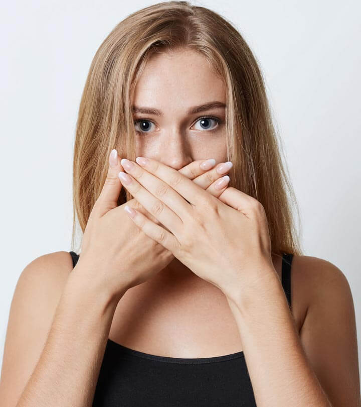 Cure bad breath, woman holding hands over her mouth