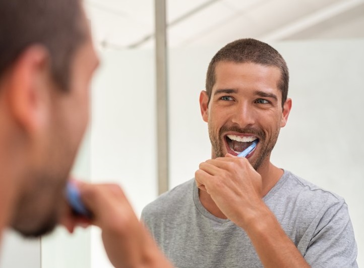 toothbrushing mistakes, man brushing his teeth